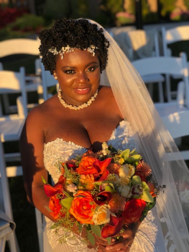 Bride holds sundrenched bridal bouquet featuring orange callas, orange roses, green cymbium orchids, dahlias. 
